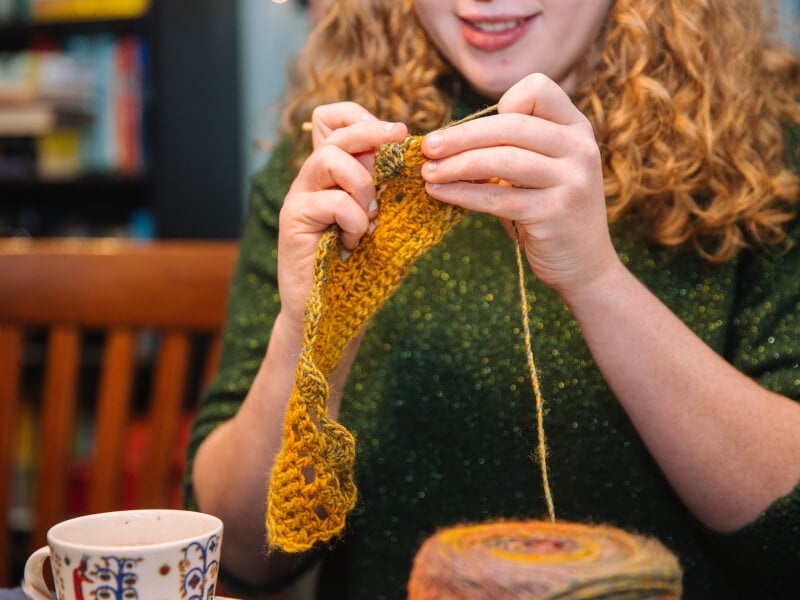 A woman knitting at a crochet class